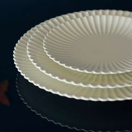 Lotus Ivory porcelain plates with a fluted design and ivory finish